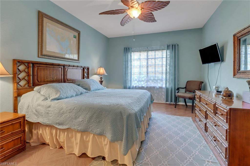 20140 Estero Gardens Circle, Unit 101 Estero, FL 33928 - Photo 13 of 40 a bedroom with a bed and a chandelier