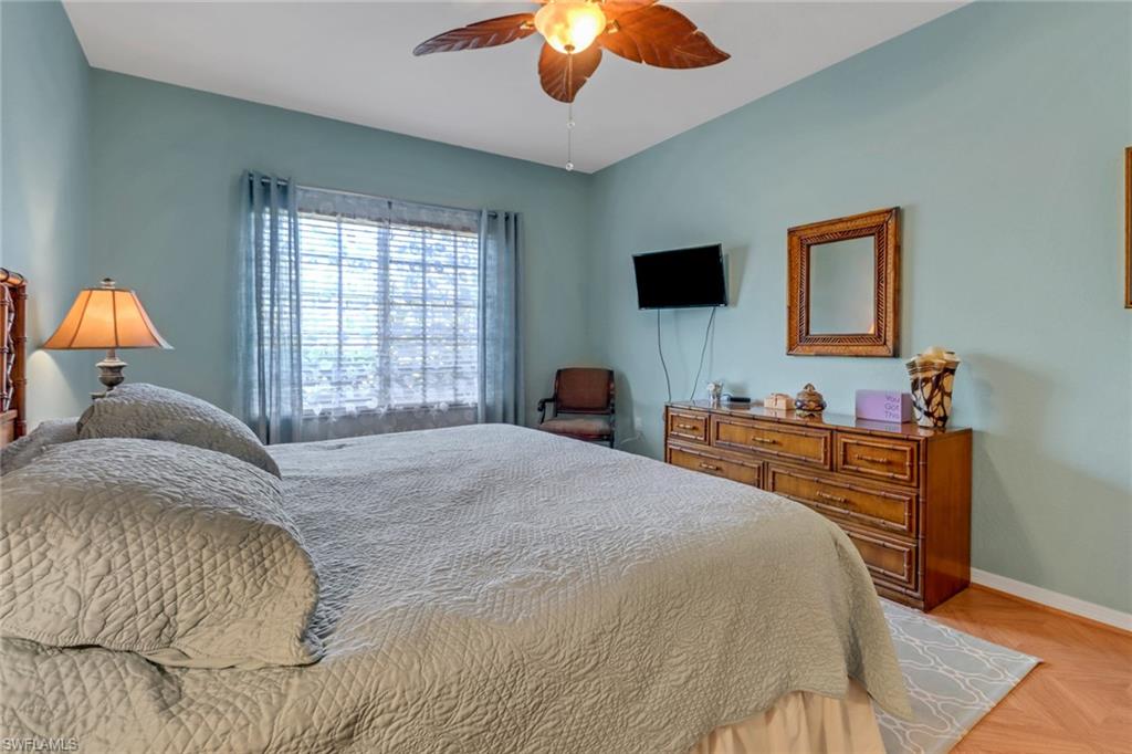 20140 Estero Gardens Circle, Unit 101 Estero, FL 33928 - Photo 14 of 40 a bedroom with a bed and a chandelier