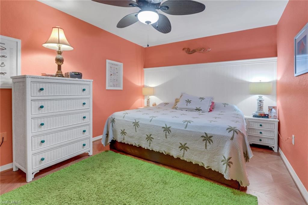 20140 Estero Gardens Circle, Unit 101 Estero, FL 33928 - Photo 17 of 40 a bedroom with a bed and a chandelier