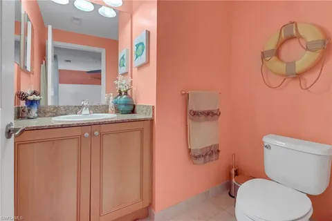 a bathroom with a granite countertop toilet sink and mirror