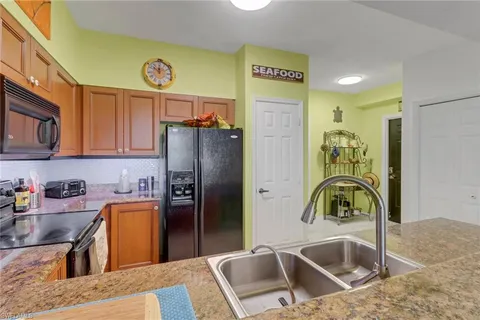 a kitchen with stainless steel appliances granite countertop a microwave a refrigerator a sink and dishwasher