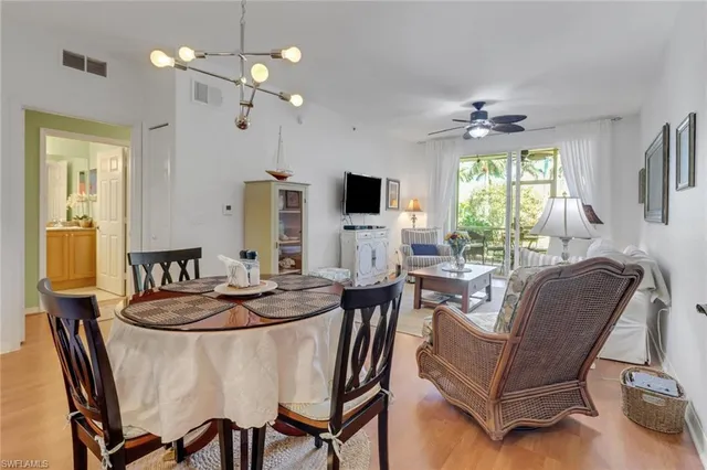 a dining room with furniture a chandelier and window