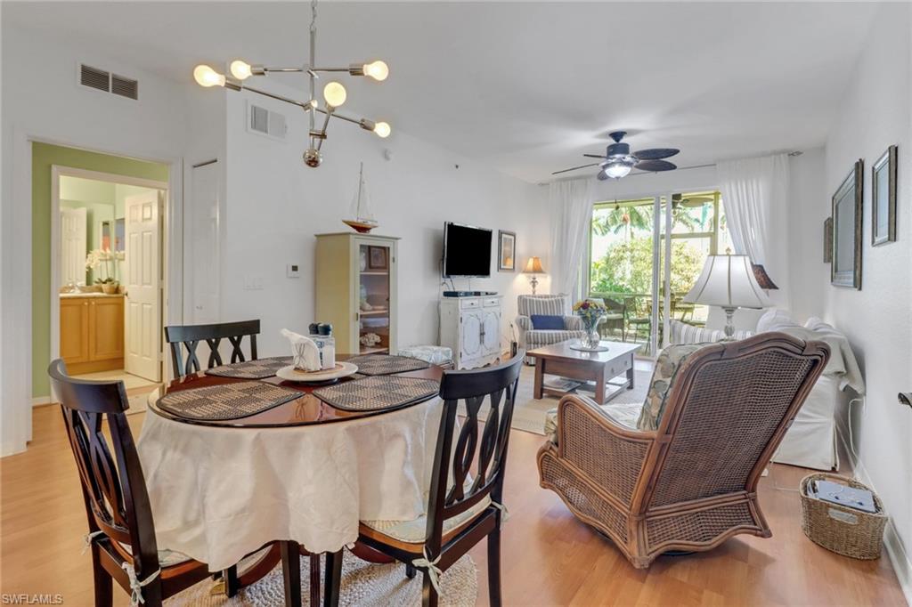 20140 Estero Gardens Circle, Unit 101 Estero, FL 33928 - Photo 9 of 40 a dining room with furniture a chandelier and window