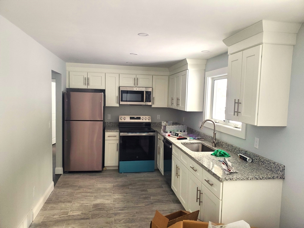 41 Easy Street Sudbury, MA 01776 - Photo 3 of 11 a kitchen with a sink stove and refrigerator