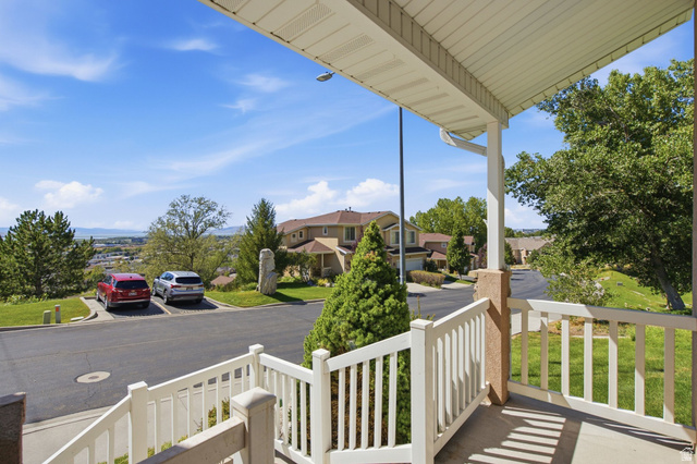 1305 Alpine Way Provo, UT 84606 - Photo 41 of 56 Covered outdoor porch with white railing, textured pillar, and concrete flooring