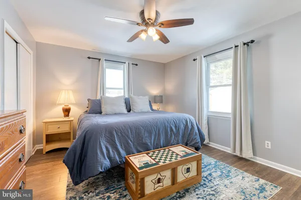 a bedroom with a bed and a window with wooden floor