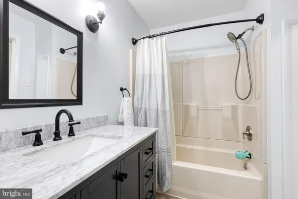 a bathroom with a granite countertop sink a mirror a vanity and a shower