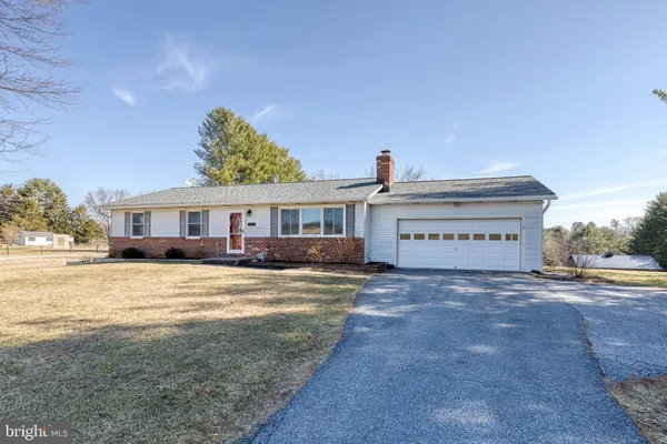 a view of a house with a yard covered with snow in the background