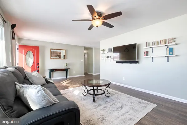 a living room with furniture a flat screen tv and a rug