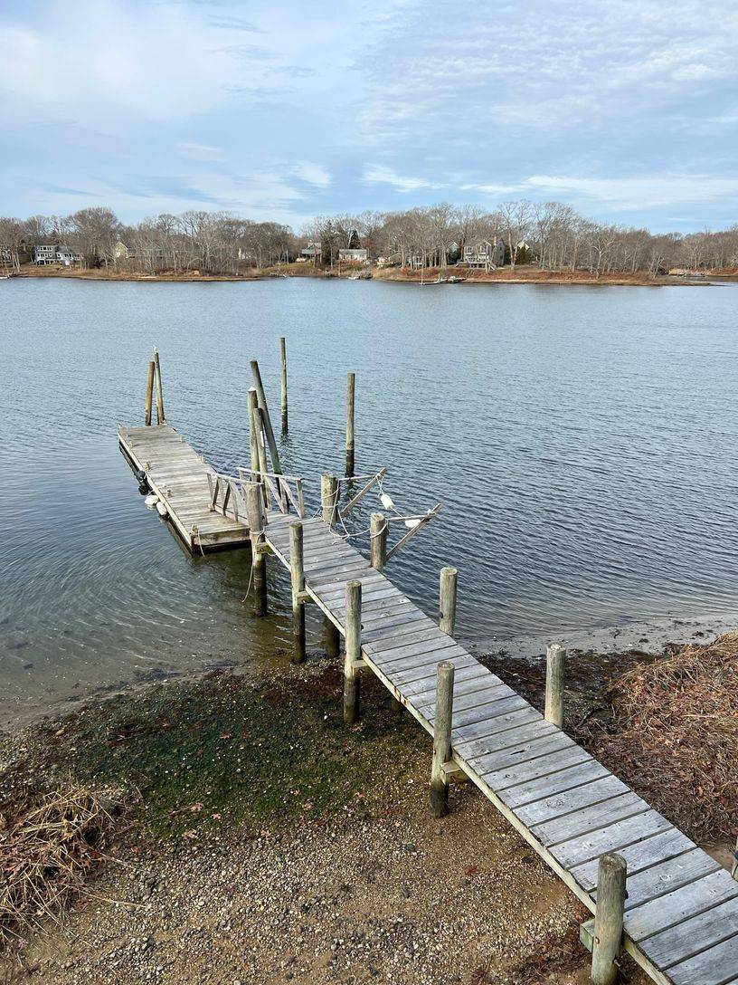 24 South Midway Road Shelter Island, NY 11964 - Photo 29 of 29 a wooden bench sitting next to a lake