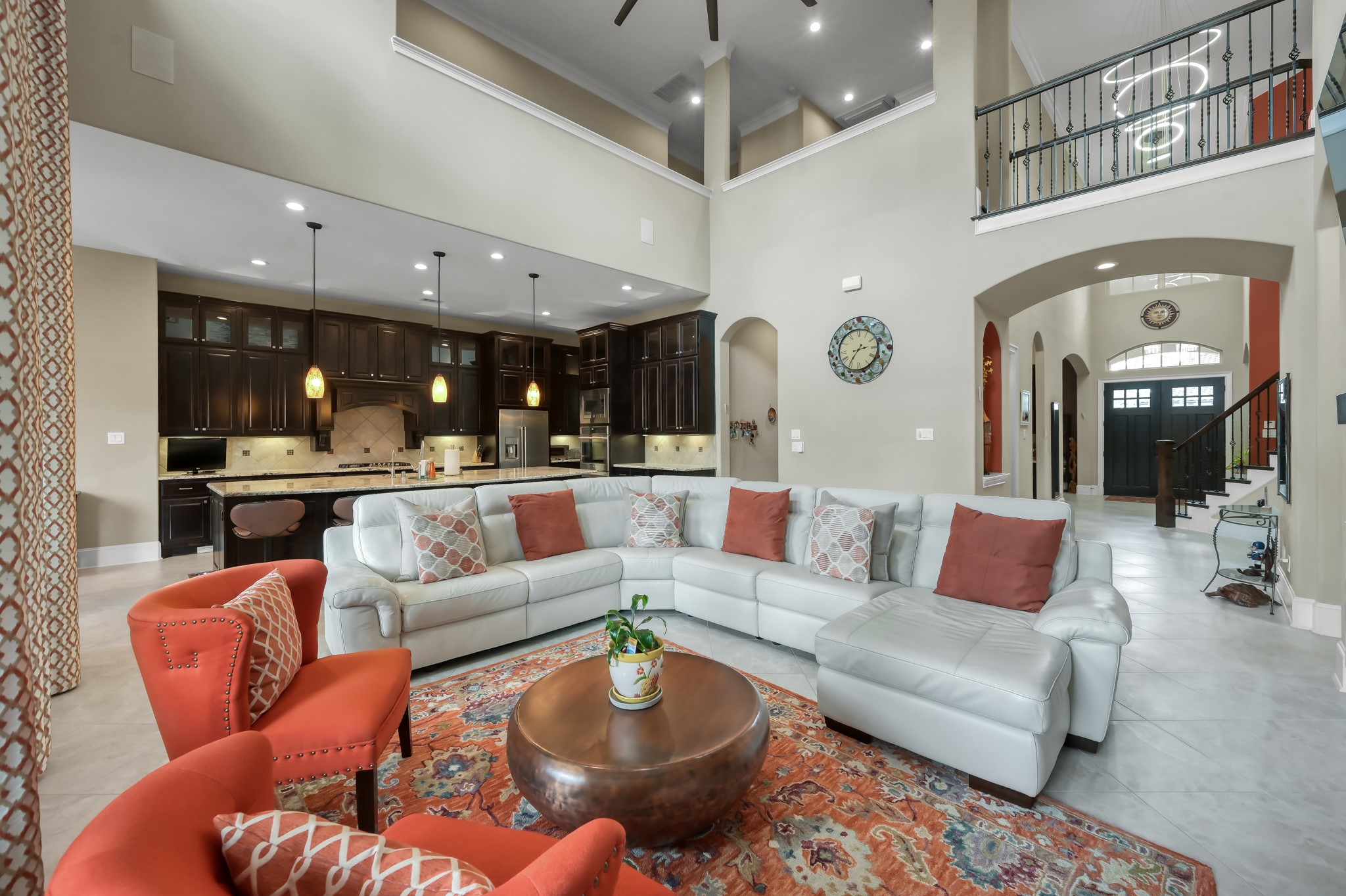 26 Woodborough Way Spring, TX 77389 - Photo 12 of 43 This spacious living area features high ceilings, abundant natural light, and an open layout connecting to a modern kitchen with dark cabinetry.