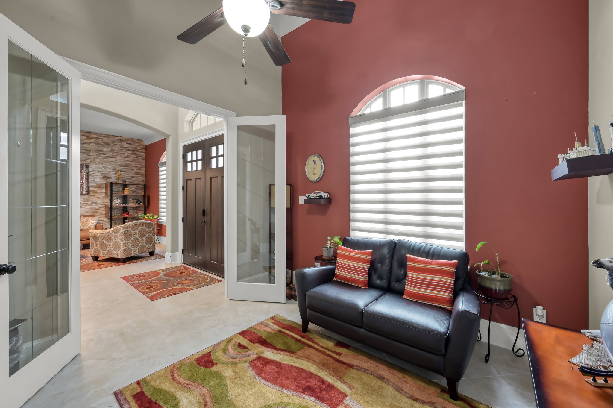 26 Woodborough Way Spring, TX 77389 - Photo 14 of 43 This office space is enhanced by a ceiling fan, arched windows with modern blinds, and warm red walls.