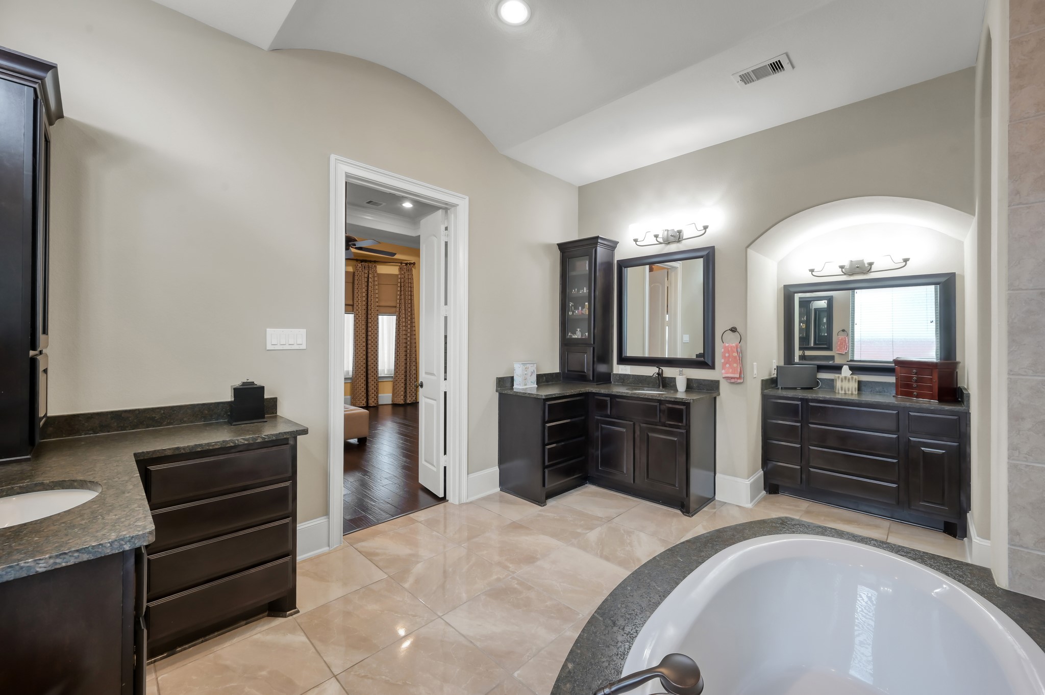 26 Woodborough Way Spring, TX 77389 - Photo 21 of 43 Discover the elegance of this primary bath, featuring two separate countertops and a chic dressing table, perfect for a luxurious and functional retreat.