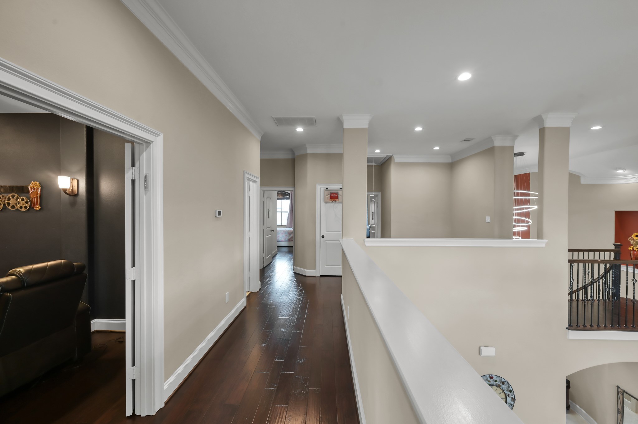 26 Woodborough Way Spring, TX 77389 - Photo 35 of 43 This photo showcases a bright upstairs hallway with elegant dark wood flooring, recessed lighting, and neutral walls.