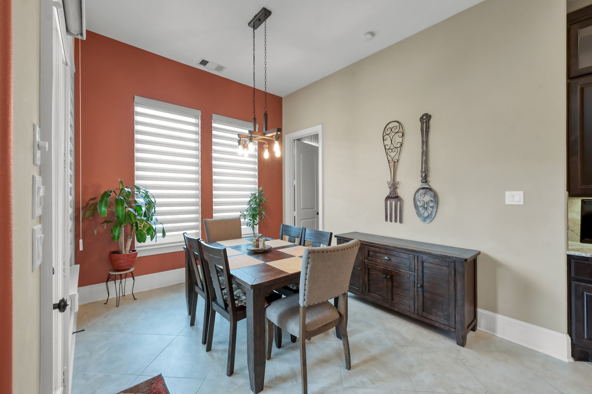 26 Woodborough Way Spring, TX 77389 - Photo 9 of 43 This inviting breakfast area features warm terracotta walls, stylish lighting, and ample natural light, creating a cozy and charming space perfect for morning gatherings.