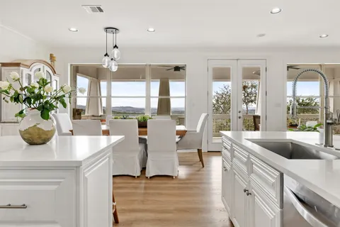 a view of living room kitchen with stainless steel appliances granite countertop furniture and a large window