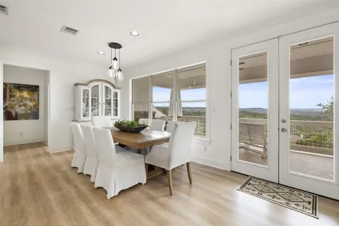 a very nice looking dining room with kitchen island stainless steel appliances furniture a fireplace and a chandelier