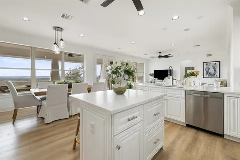 a kitchen with stainless steel appliances white cabinets sink and stove