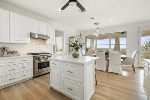 a kitchen with a stove and white cabinets