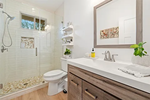 a bathroom with a sink a toilet and shower