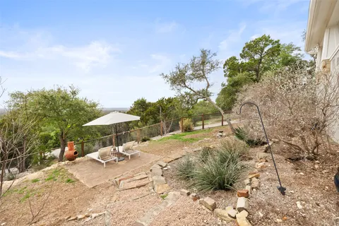 a view of a patio with a table and chairs under an umbrella