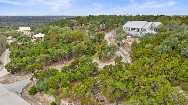 an aerial view of a house with a yard and large tree