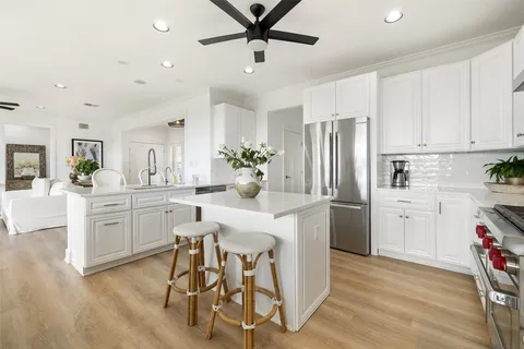 a kitchen with white cabinets and stainless steel appliances