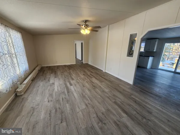 a view of a livingroom with wooden floor and a ceiling fan