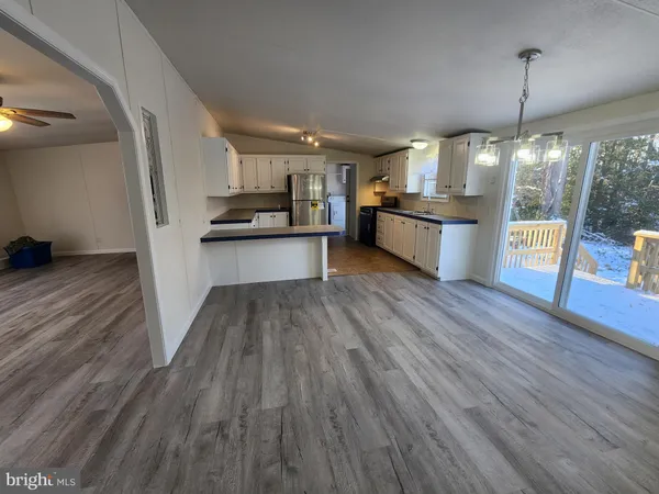 a kitchen with stainless steel appliances wooden floor and large windows
