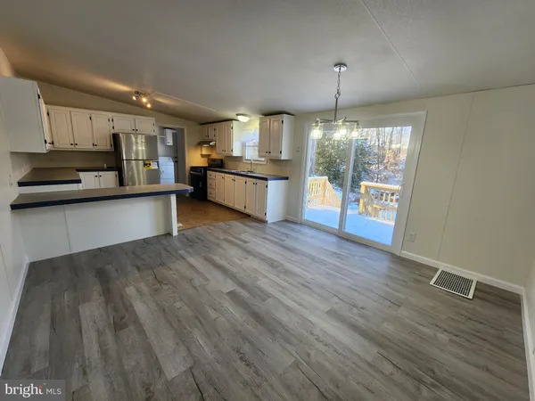 a kitchen with stainless steel appliances granite countertop a sink cabinets and wooden floor