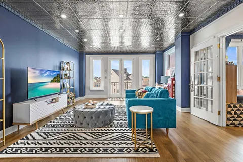 a living room with furniture a flat screen tv and a floor to ceiling window