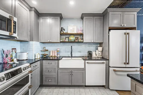 a kitchen with white cabinets and white appliances