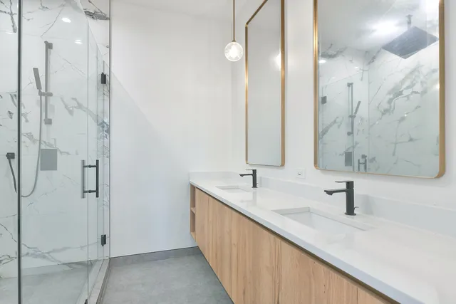 a bathroom with a double vanity sink a mirror and shower