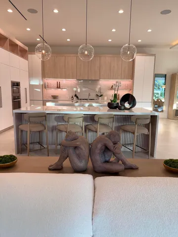 a large kitchen with kitchen island a large window a sink and stainless steel appliances