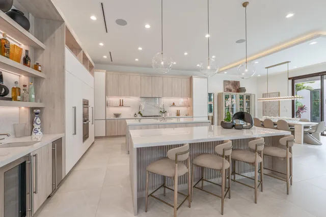 a large white kitchen with a large window and stainless steel appliances