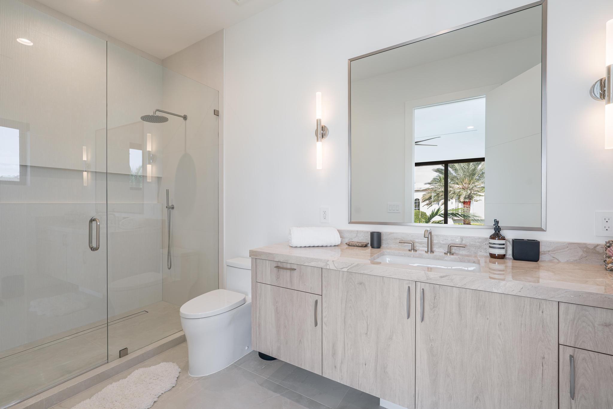 400 Northeast 4th Street Boca Raton, FL 33432 - Photo 47 of 73 a bathroom with a double vanity sink toilet mirror and shower