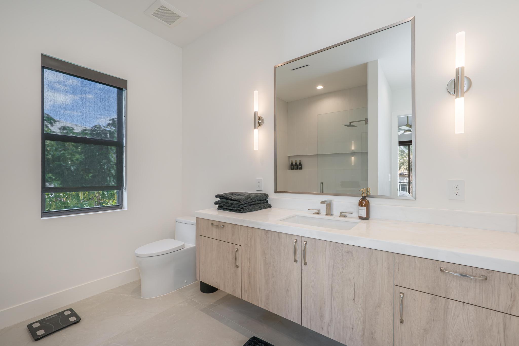 400 Northeast 4th Street Boca Raton, FL 33432 - Photo 52 of 73 a bathroom with a double vanity sink a toilet and a mirror