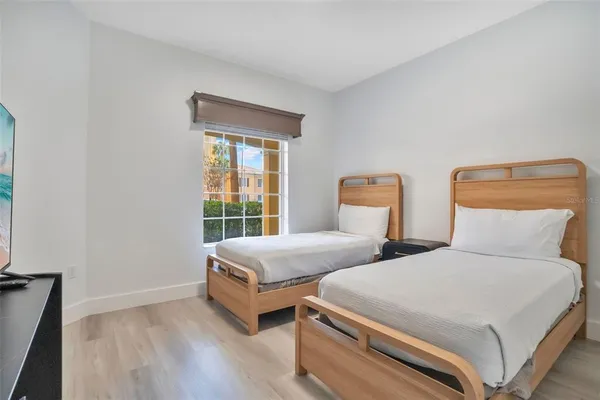 a bedroom with two beds and a window