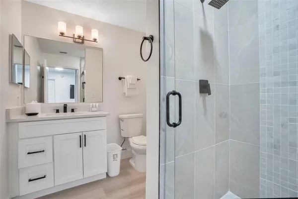 a bathroom with a granite countertop sink a toilet and a mirror