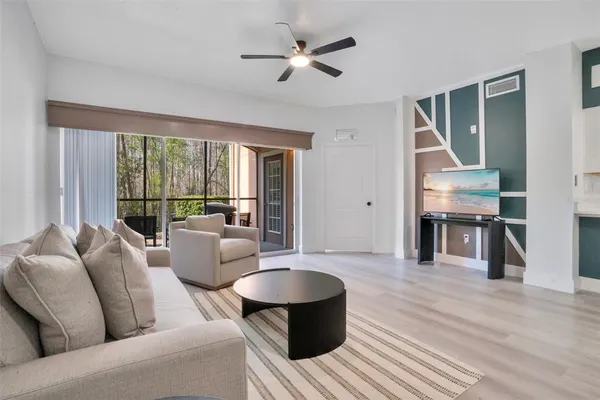 a living room with furniture and a wooden floor