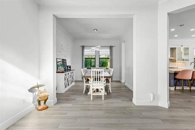 a dining room with furniture a chandelier and wooden floor