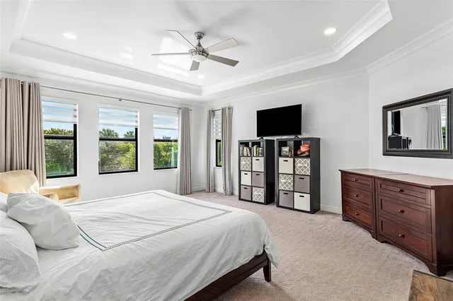 a bedroom with a large bed and a flat tv screen on dresser