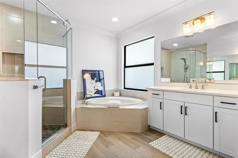 a spacious bathroom with a double vanity sink a mirror and a bathtub
