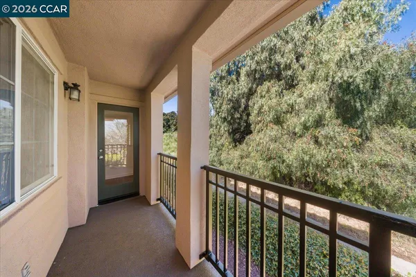a view of a balcony with wooden floor and fence
