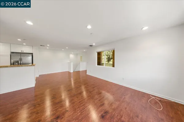 a view of empty room with wooden floor