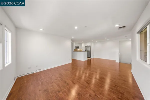a view of empty room with wooden floor