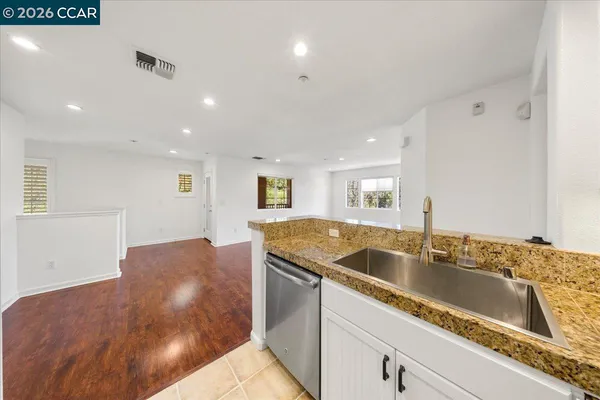 a kitchen with granite countertop sink and natural light
