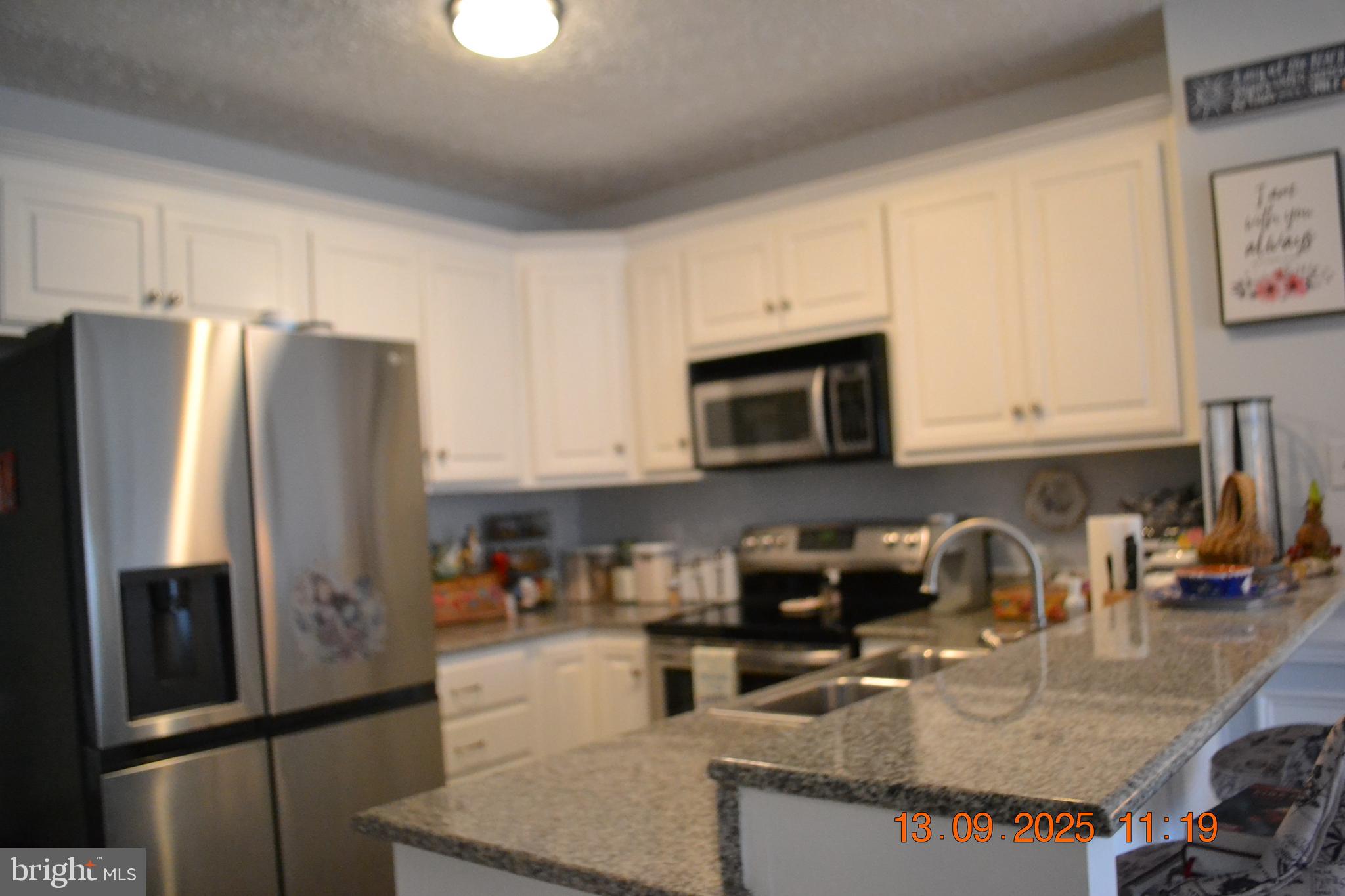 100 Taylor Street, Unit 206 Colonial Beach, VA 22443 - Photo 11 of 26 a kitchen with granite countertop a refrigerator and a sink