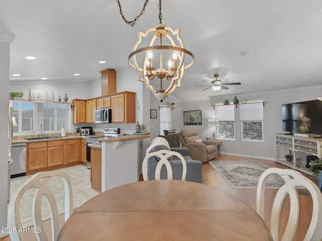 a very nice looking open dining room with kitchen island granite countertop a sink a stove and a chandelier