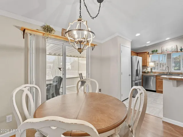 a dining room with furniture a chandelier and wooden floor